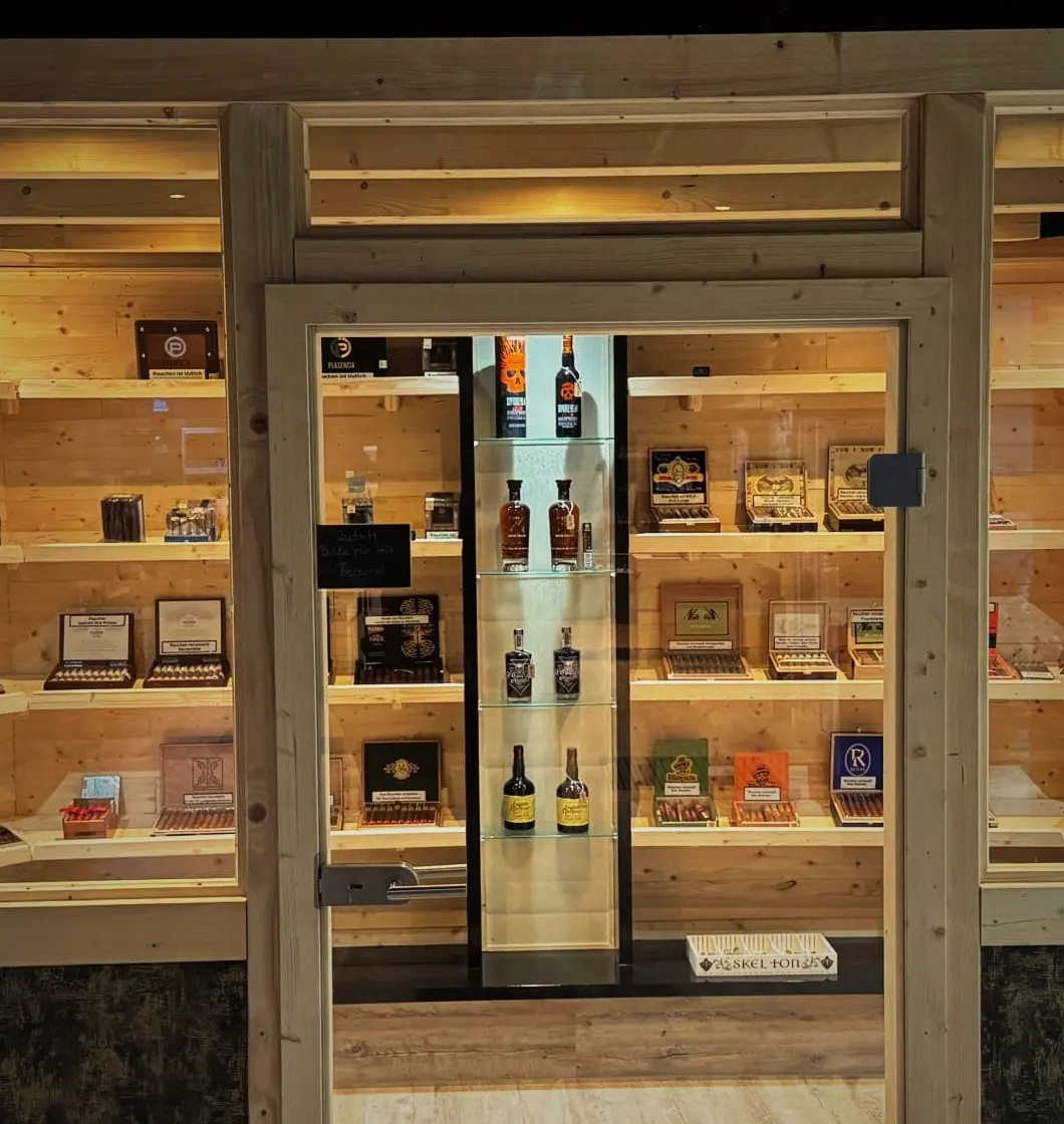 Glastür des begehbaren Humidors mit Zigarrenkisten dahinter